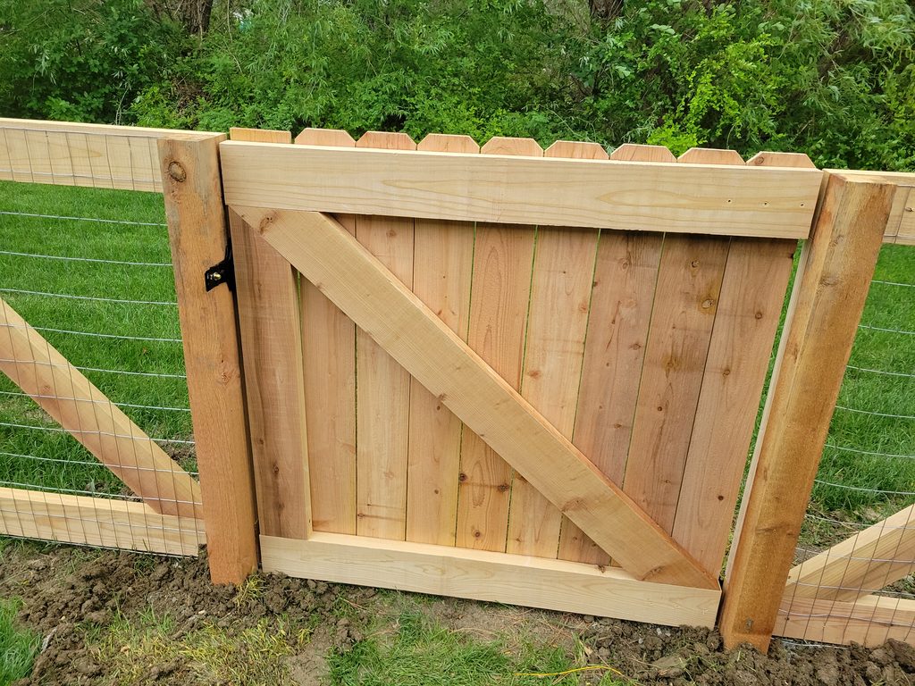 Custom wood fence gate with wire fencing