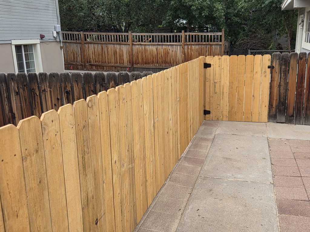 New wood privacy fence installation along residential walkway